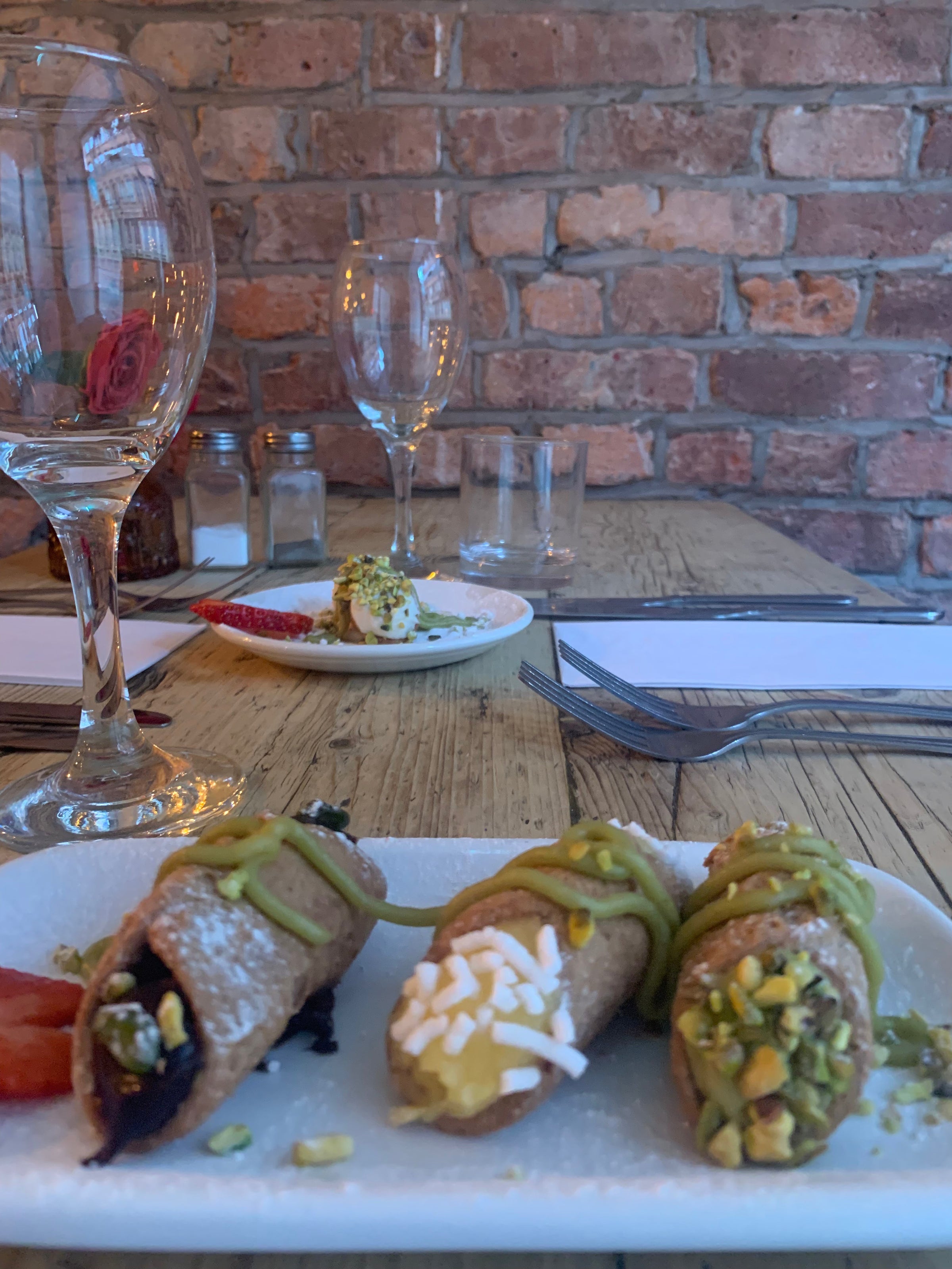 Tre cannolicchi vegani artigianali con crema e guarnizioni, serviti su piatto elegante al Sicilian NQ