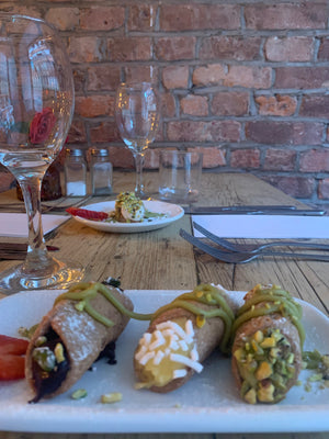 Tre cannolicchi vegani artigianali con crema e guarnizioni, serviti su piatto elegante al Sicilian NQ