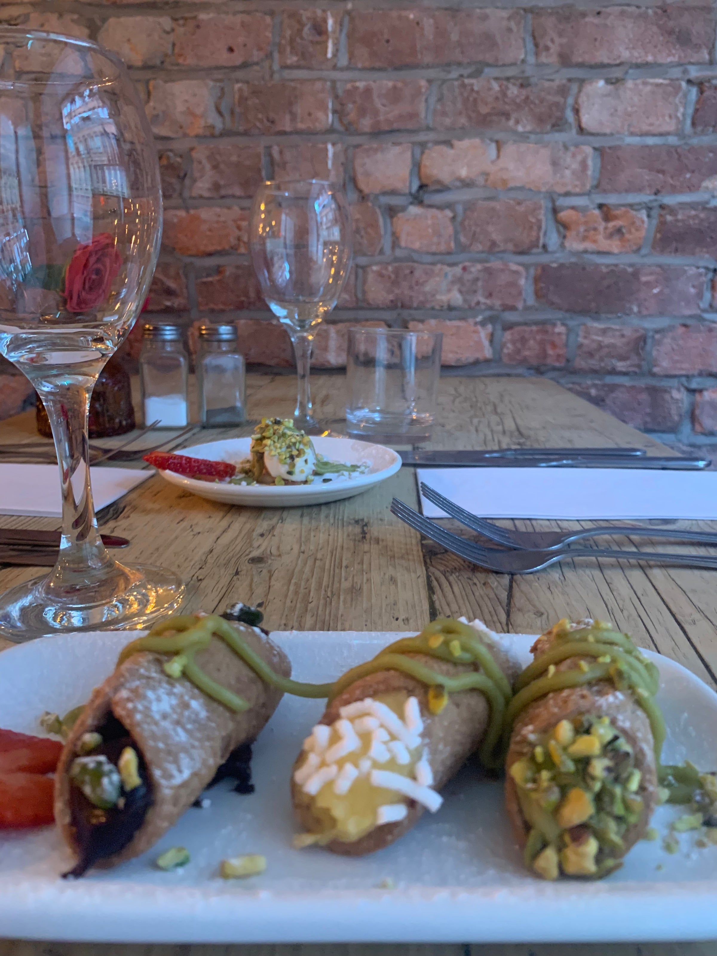 Tre cannolicchi vegani artigianali con crema e guarnizioni, serviti su piatto elegante al Sicilian NQ