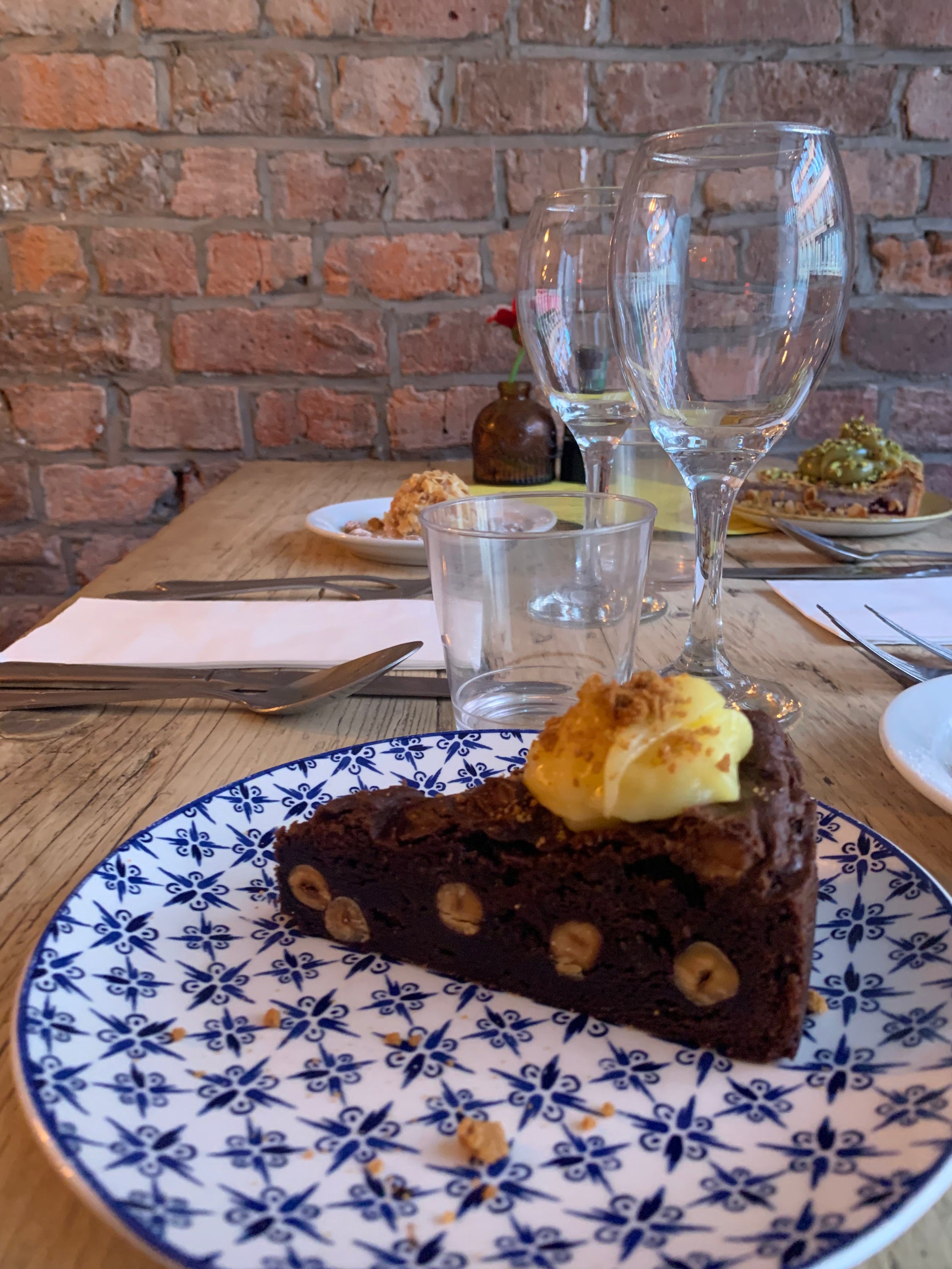 Brownie vegana artigianale al cioccolato fondente su piatto colorato, servita come dessert in ristorante