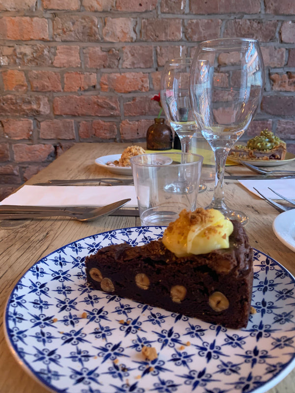 Brownie vegana artigianale al cioccolato fondente su piatto colorato, servita come dessert in ristorante